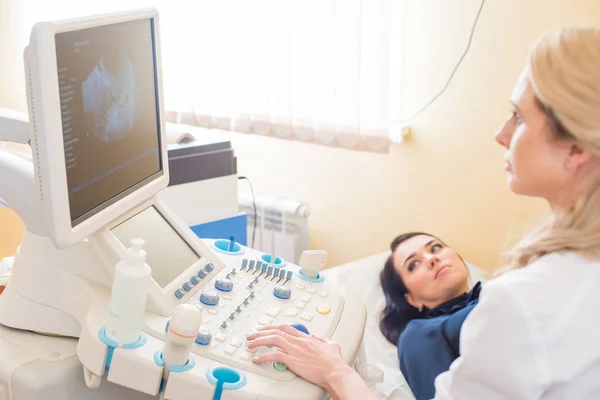 Ultrasound test. Pregnancy. Gynecologist checking fetal life with scanner. Exam.