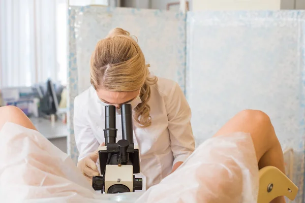 Ginecólogo profesional examinando a su paciente femenino en una silla ginecológica — Foto de Stock