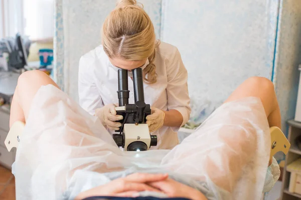 Ginecólogo profesional examinando a su paciente femenino en una silla ginecológica — Foto de Stock