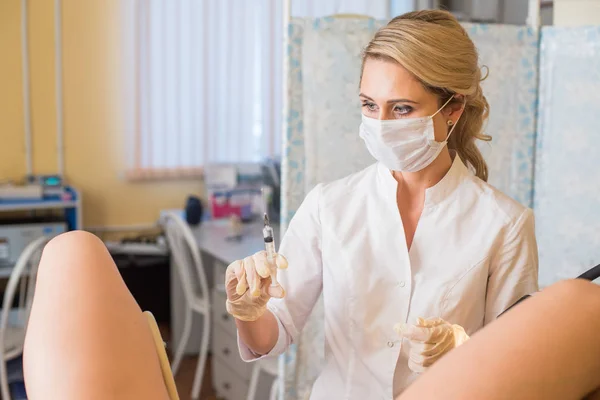 Gynekolog gör en injektion. Attraktiva läkare gynekolog behandlar patienten. — Stockfoto