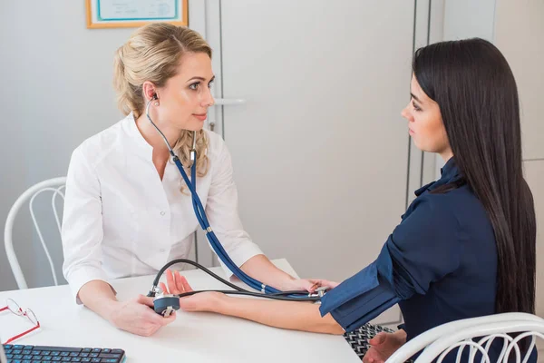 医師は妊娠中の女性の圧力の測定します。医師のオフィスでメスの患者の血圧を取って — ストック写真