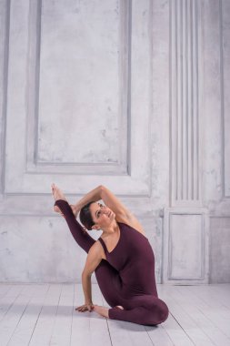 Kadın bir spor salonunda meditasyon. Sportif genç kadının açık renkli Yoga pratik yapması.