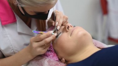 Profesyonel Şevval Özçelik Güzellik kirpik uzatma yordamı geçiyor. Ana ve bir istemcinin, modern bir Güzellik Salonu