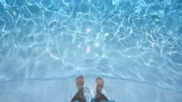 Harige mannelijke poten in blauw helder water, buitenzwembad, zonlicht. — Stockvideo