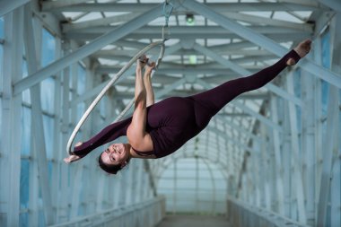Bir hava jimnastikçi, metal bir kafes üzerinde askıya alınan bir hava çemberinde Rus böler yapar. havadar yüzük üzerinde sirk aktris.