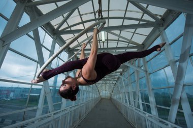 Bir hava jimnastikçi, metal bir kafes üzerinde askıya alınan bir hava çemberinde Rus böler yapar. havadar yüzük üzerinde sirk aktris.