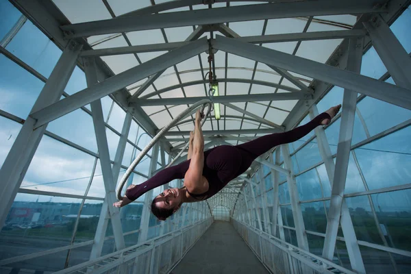 Een Air turnster maakt een Russische splitst op een lucht hoepel geschorst op een metalen truss. Circus actrice op de luchtige ring. — Stockfoto