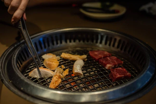 Świeżego mięsa. Grillowania mięsa w koreańskiej restauracji. Tradycyjne dania kuchni koreańskiej. — Zdjęcie stockowe