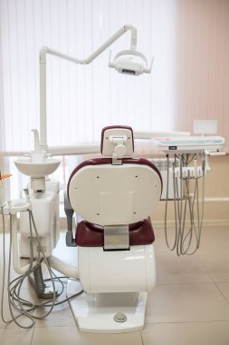 Parlak bir tıbbi ofiste boş diş sandalye, arka görüş.