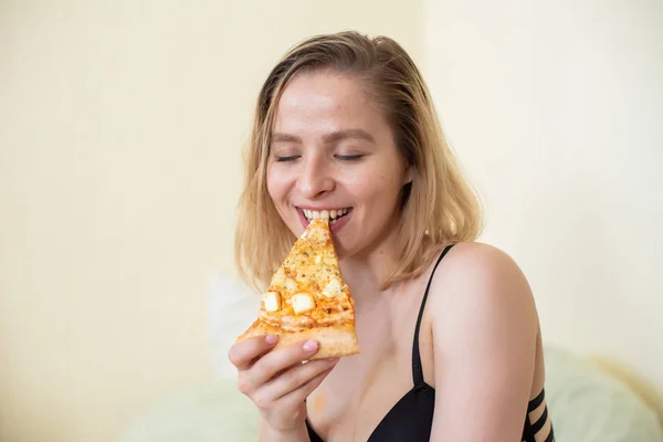 Ragazza europea con i capelli corti in posa con pezzi di deliziosa pizza . — Foto Stock