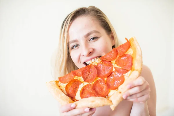 Chica europea con el pelo corto posando con trozos de deliciosa pizza . — Foto de Stock