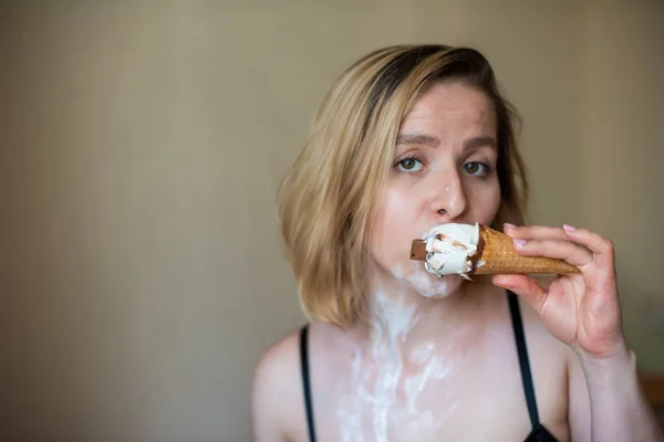 Sexy rubia lame un cono de gofre. El helado se está derritiendo, drenando eróticamente el cuerpo de una mujer atractiva. Hermosa chica untada con helado. — Foto de Stock