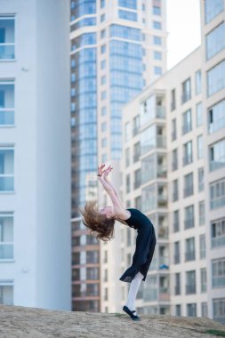 Ballerina bir tutu bir konut binanın arka plana karşı poz. Siyah elbise ve Pointe ayakkabılar dans bale dışında güzel genç kadın.