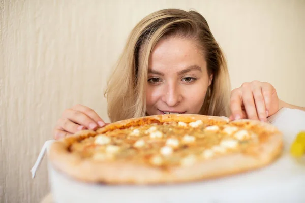 ピザを食べている女性の肖像。ピザを食べる黒い下着の美しい若い女性 — ストック写真