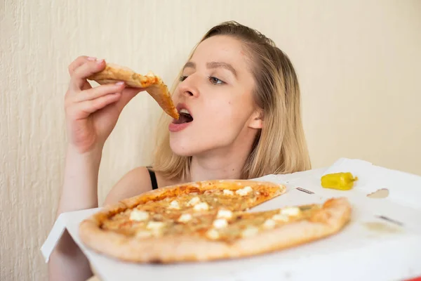Retrato de una mujer comiendo pizza. Hermosa joven en ropa interior negra comiendo pizza —  Fotos de Stock