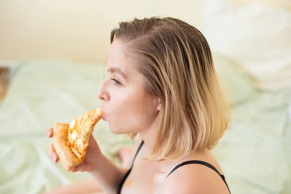 Ragazza europea con i capelli corti in posa con pezzi di deliziosa pizza . — Foto Stock