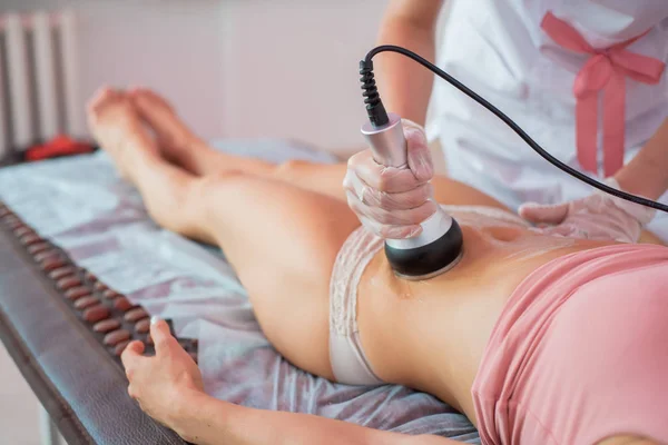 Procedur ta bort celluliter på kvinnlig buk, kavitation mage massage. Ultraljudsmassage för viktminskning. Korrigering av en kvinnlig figur utan kirurgiskt ingrepp. Närbild av magen. — Stockfoto