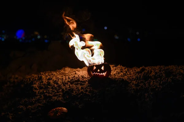 Lenguas de llama en una calabaza. Jack-o-linterna en llamas sobre un fondo negro. Símbolo de Halloween en el suelo. Truco o trato. De cerca. . — Foto de Stock
