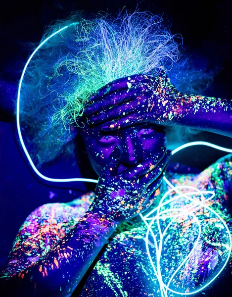 Vücut sanatı ve kontakt lensler ultraviyole ışıkta parlıyor. Floresan tozuyla boyanmış bir kadının portresi. Gözlerindeki yıldızlar. Neon ışık şerit. — Stok fotoğraf