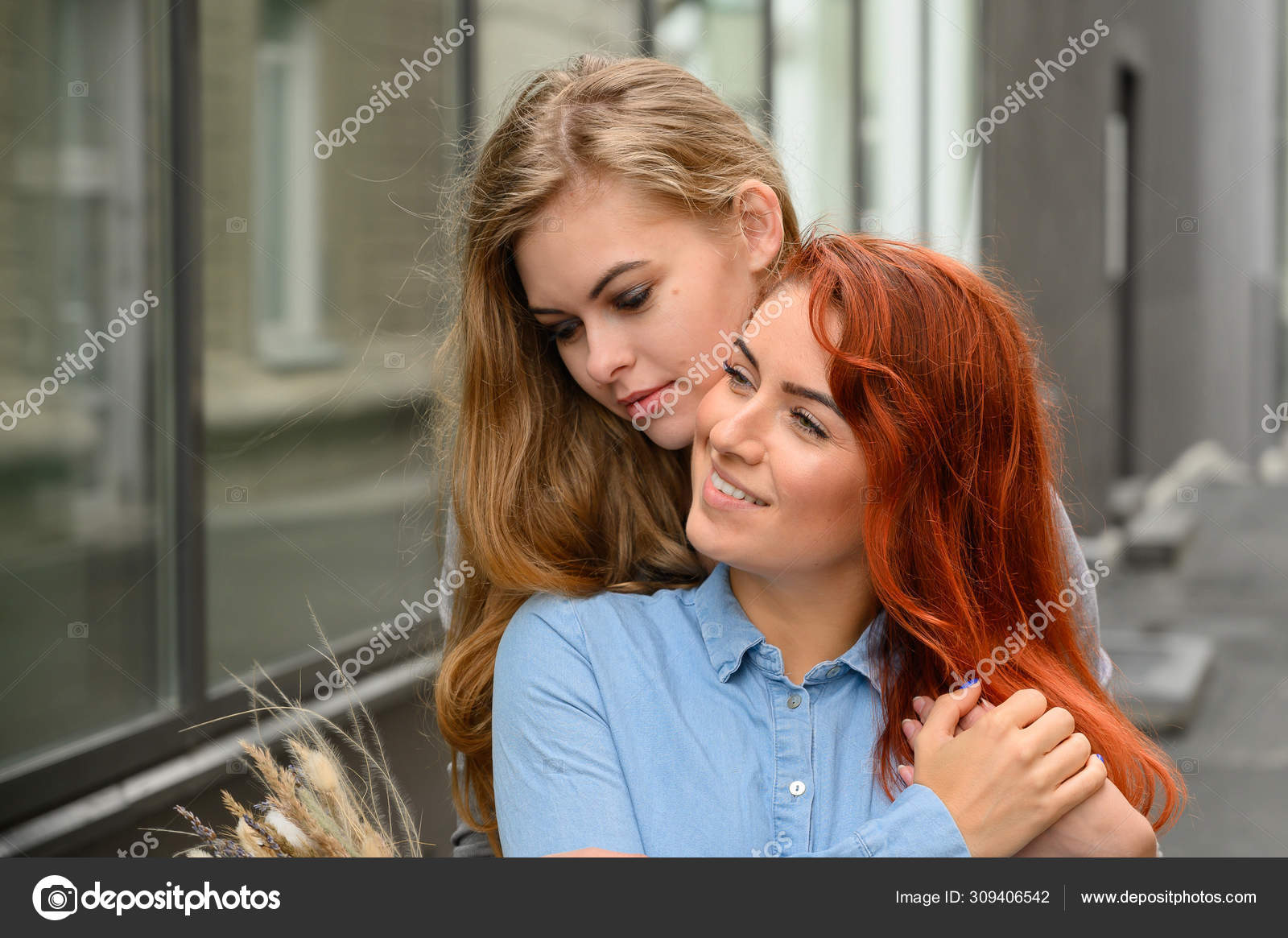 Same-sex relationships. Happy lesbian couple with dried flowers. The girl gently hugs the red-haired girlfriend from behind photo