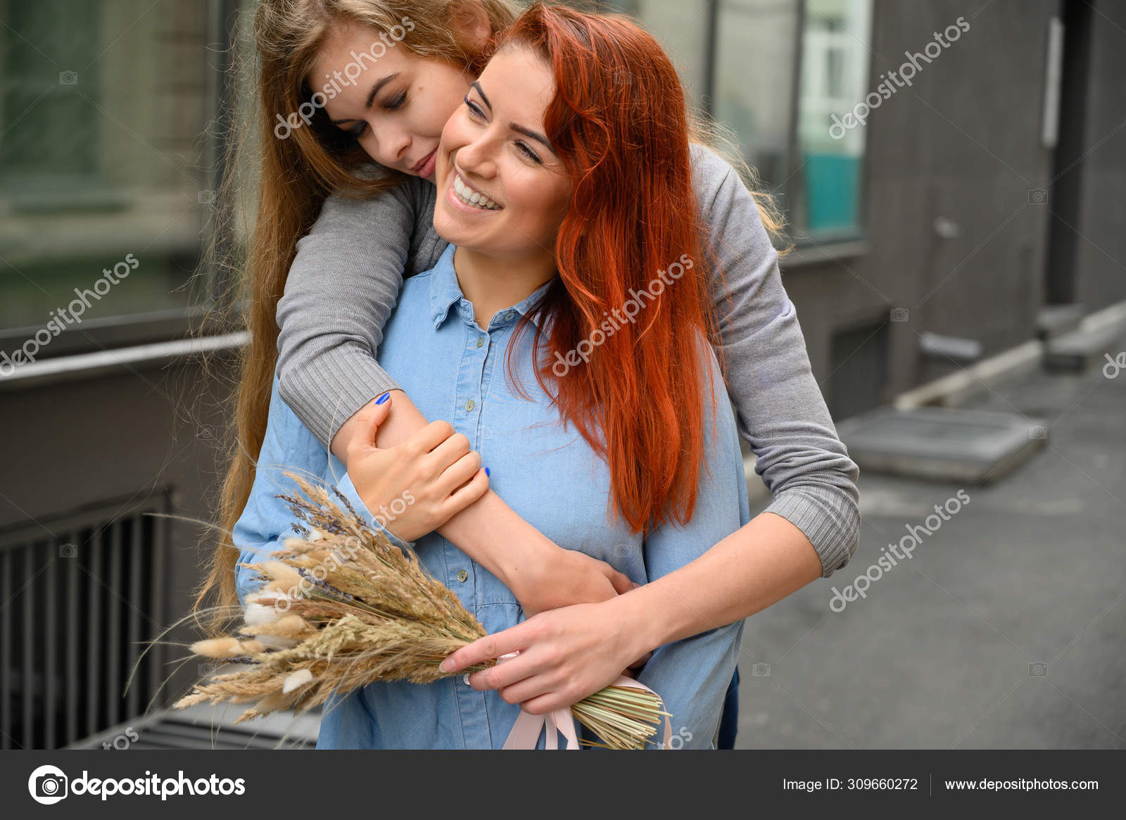 Close Up Of Lesbian Couple Embracing In The Bedplay Phone Happily Stock Photo