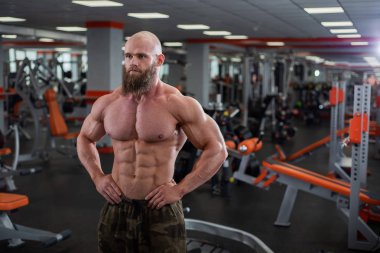 Gömleksiz erkek vücut geliştirmeci spor salonunda poz. Yarışma dan önce bir diyet rölyef atlet. Kaslı göğüs erkekler. Büyük fiziksel şekil