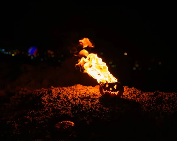 Tongues of flame in a pumpkin. jack-o-lantern on fire on a black background. Halloween symbol on the ground. Trick or treat. Close up. — Stock Photo, Image