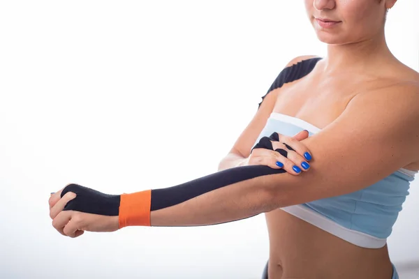 Bir kadın atlet bileğine kineziotape koyar. Kineziology, eklem ve tendon yaralanmaları için alternatif tedavi. Bir kadın kol eklemkronik iltihabı Fizyoterapi. — Stok fotoğraf