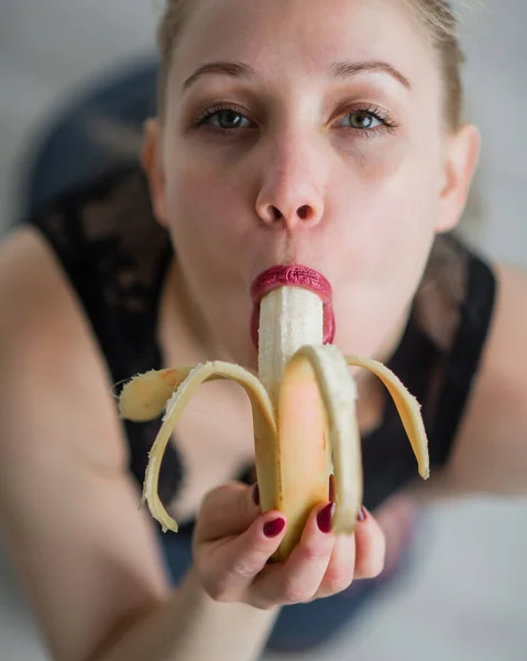 Adulte fille européenne lèche sexuellement et suce une grosse banane. Fantasmes sur le sexe oral. Gros plan sur le visage . — Photo