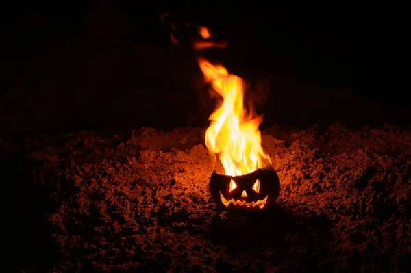 Γλώσσες φλόγας σε κολοκύθα. ο Τζακ-ο-φανάρι καίγεται σε μαύρο φόντο. Το αποκριάτικο σύμβολο στο έδαφος. Κόλπο ή κέρασμα. Κοντινό. — Φωτογραφία Αρχείου