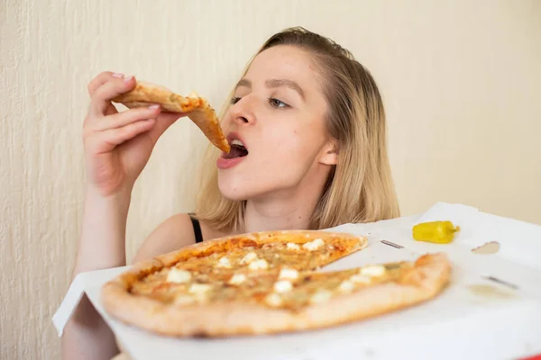 Portré egy nő eszik pizzát. Gyönyörű fiatal nő fekete fehérnemű étkezési pizza — Stock Fotó