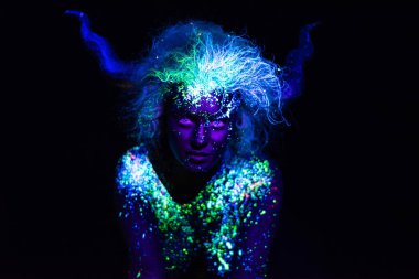 şeytan makyaj ve kontakt lensler. Ultraviyole vücut boyama kadın. Kız floresan tozuyla boyanmış. Uv ışıkta parlayan vücut sanatı. Gözlerindeki yıldızlar.