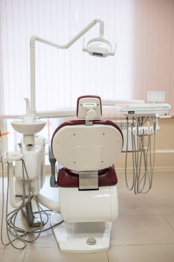 Parlak bir tıbbi ofiste boş diş sandalye, arka görüş.