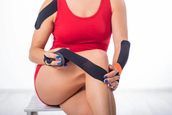 Sporcu dizine Kinesio bandı takar. Kineziyoloji, eklem ve tendon yaralanmaları için alternatif bir tedavi. Kadın bacağındaki eklemlerde kronik iltihaplanma fizyoterapisi. — Stok fotoğraf