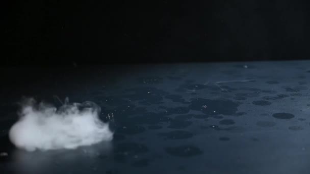 Soap bubbles with smoke inside fall on a black table and burst. Slow Motion Dark Background. — Stock Video