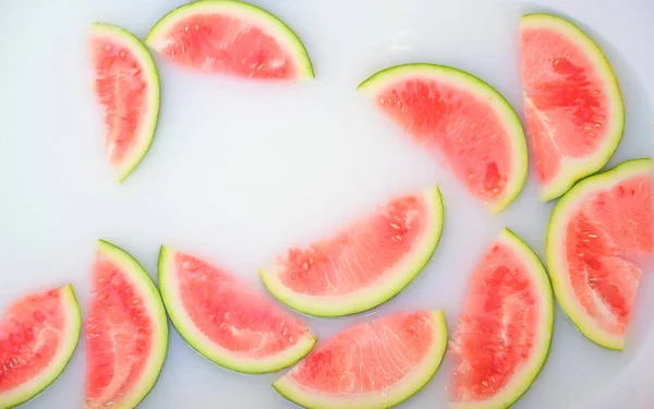 Turbid soapy water in bath with slices of watermelon. top view in full frame. The largest berry. spa with milk in the bath for rejuvenation.. — Stock Photo, Image