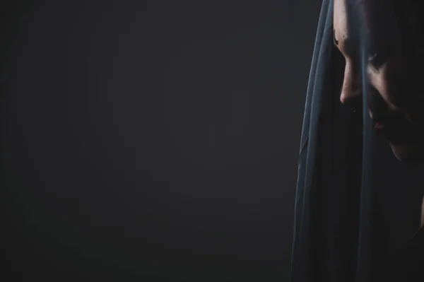 Egy fekete fátyolos nő profilja. Halott menyasszony jelmezben Halloweenkor. Egy gonosz vigyorgó boszorkány portréja egy koven előtt.. — Stock Fotó
