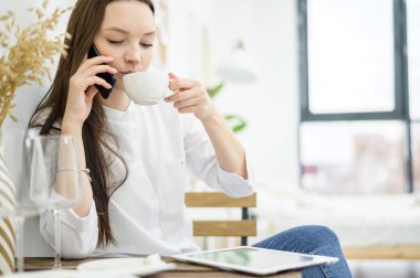 Beyaz gömlekli bir kadın bir kafede kahve içiyor. Öğle yemeği molasında olan bir kadın ofis çalışanı iş sorununu telefonla çözer. Orta seviye yönetici
