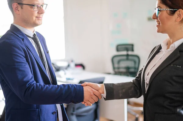 在一笔成功的交易结束时,男女商人握手握手.办公室工作人员在问候时穿着西装。成功的工作面试. — 图库照片