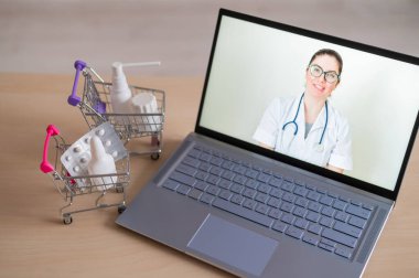 İnternet tıbbı. Kadın doktorda uzaktan resepsiyon. Bir eczanede ev teslimatı ile birlikte ilaç satın almak için bilgisayar başvurusu. Eczacı dizüstü bilgisayar ekranında ilaç öneriyor..