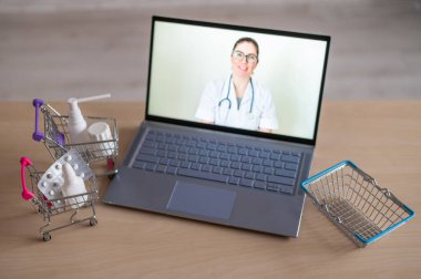 İnternet tıbbı. Kadın doktorda uzaktan resepsiyon. Bir eczanede ev teslimatı ile birlikte ilaç satın almak için bilgisayar başvurusu. Eczacı dizüstü bilgisayar ekranında ilaç öneriyor..
