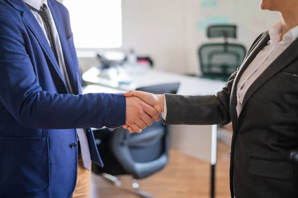 在一笔成功的交易结束时,男女商人握手握手.办公室工作人员在问候时穿着西装。成功的工作面试. — 图库照片