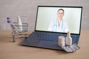 İnternet tıbbı. Kadın doktorda uzaktan resepsiyon. Bir eczanede ev teslimatı ile birlikte ilaç satın almak için bilgisayar başvurusu. Eczacı dizüstü bilgisayar ekranında ilaç öneriyor..