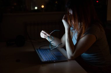 Dizüstü bilgisayarla uğraşan yorgun kızıl saçlı kadın. Umutsuzluk içinde bilgisayarın başındaki kız burun köprüsünde el ele tutuşuyor. İşteki başarısızlık. Son teslim tarihi ve fazla mesai.