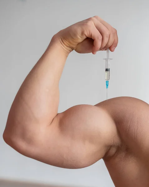 Nahaufnahme einer männlichen Hand mit einer Dosierspritze. Beschnittener Bizeps eines Mannes. Unbekannter Bodybuilder setzt sich Wachstumshormon Testosteron. — Stockfoto