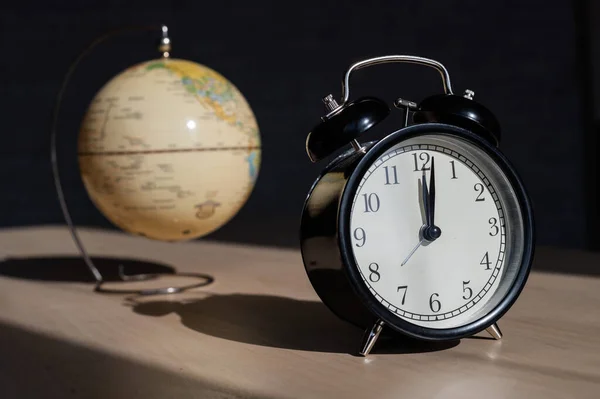 나무 탁자 위에 있는 시계와 지구. 여행 할 시간이야. 세계 시간. — 스톡 사진
