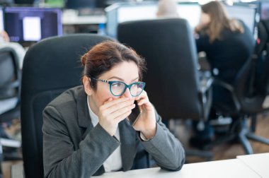Ofisinde bir kadın oturuyor ve telefonda dedikodularını yapıyor. Şirket ahlakı. Takım elbiseli kadın çalışan, iş yerindeki akıllı telefondan sırlarını anlatır..
