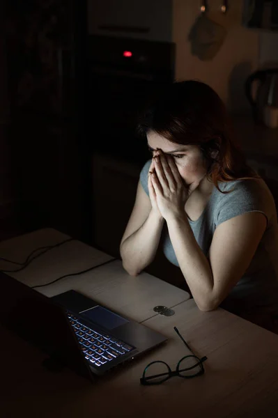 Femme fatiguée et épuisée, frustrée, faisant des heures supplémentaires sur un ordinateur portable. Une pigiste désespérée tient ses mains par le visage. Travail de nuit depuis la maison. Échéance — Photo