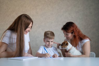 Mutlu aile evde kalır. İki kadın çocuğa okul ödevinde yardım ediyor. Lezbiyen çift, oğulları ve neşeli bir köpek yavrusuyla masada oturuyor. Bir çocukla eşcinsel bir evlilik. Uzaklık öğrenimi.