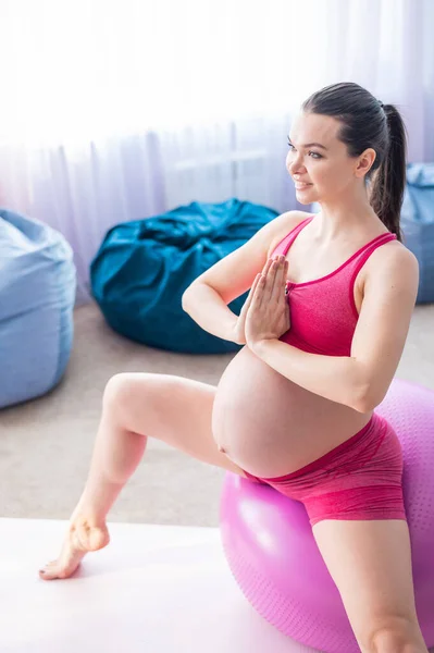 Krásná těhotná žena dělá cvičení na fitness míč. Očekávající matka v posledním trimestru dělá jógu. — Stock fotografie